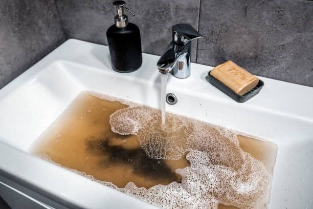 Évier engorgé par une eau sale qui ne s'écoule plus